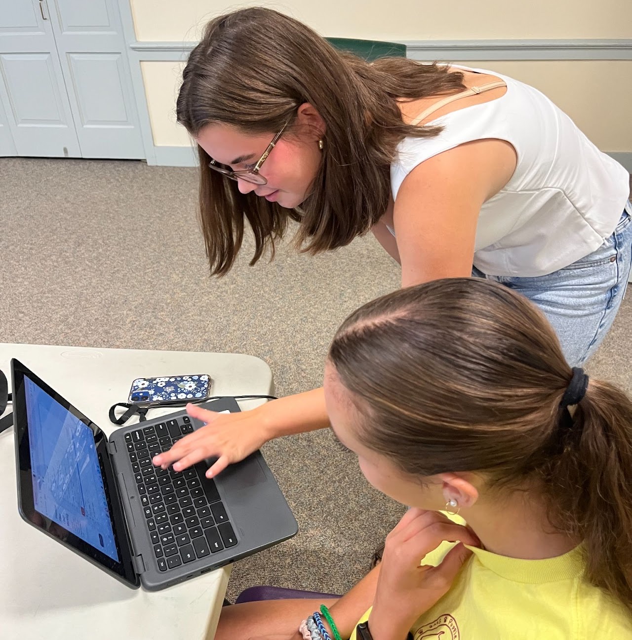 Harper helping a student at a laptop